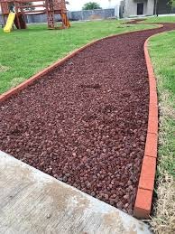 Tezontle rojo en jardín residencial de Tampico — sendero decorativo con pasto